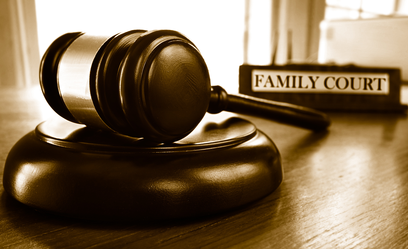 Image of gavel next to a sign that reads "family court."