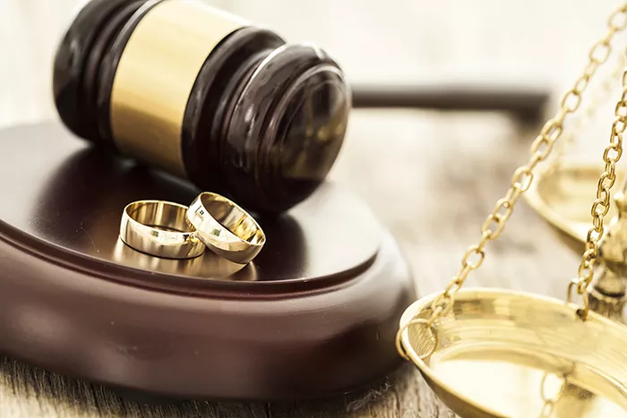 Image of two wedding bands on a gavel platform with scales to the right.